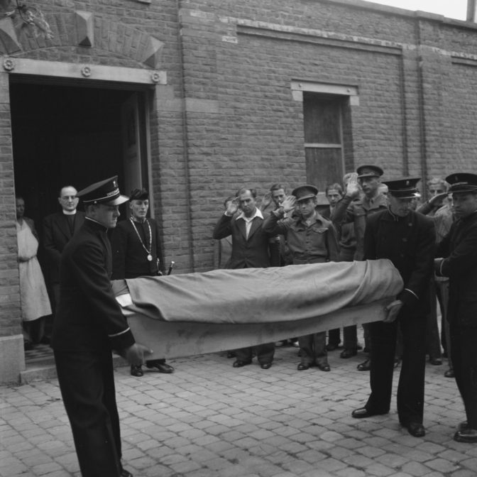 Coffin with pall carried outside